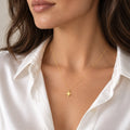 14K solid gold North Star pendant necklace on woman wearing white satin shirt