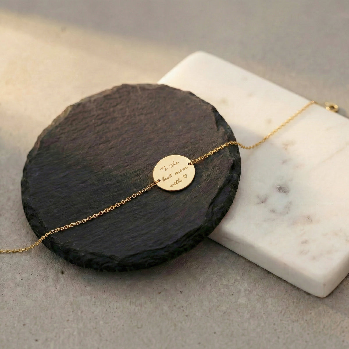 Close-up of 14K yellow gold handwriting disc bracelet