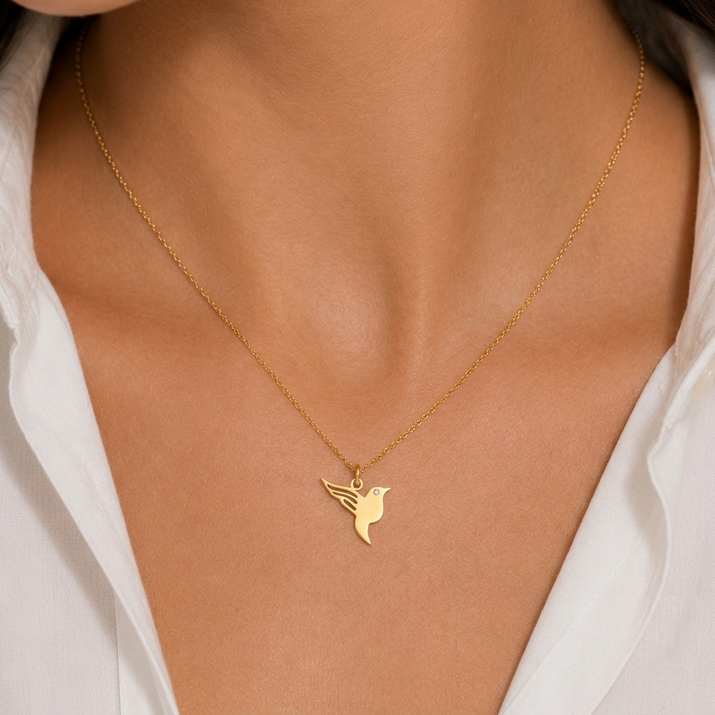14K yellow gold hummingbird diamond pendant necklace, worn at the neckline