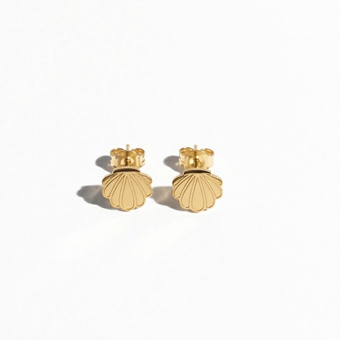 A pair of gold stud earrings shaped like scallop shells, shown on a clean white background with soft shadows.