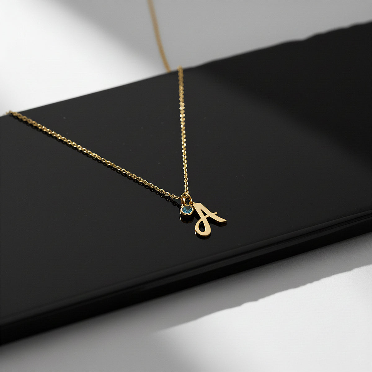 Close-up of 14K yellow gold birthstone initial necklace