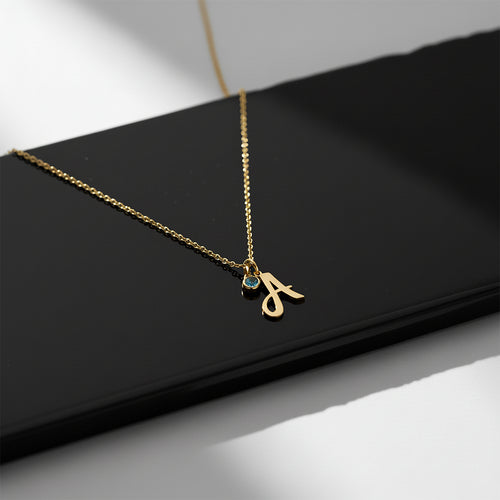 Close-up of 14K yellow gold birthstone initial necklace
