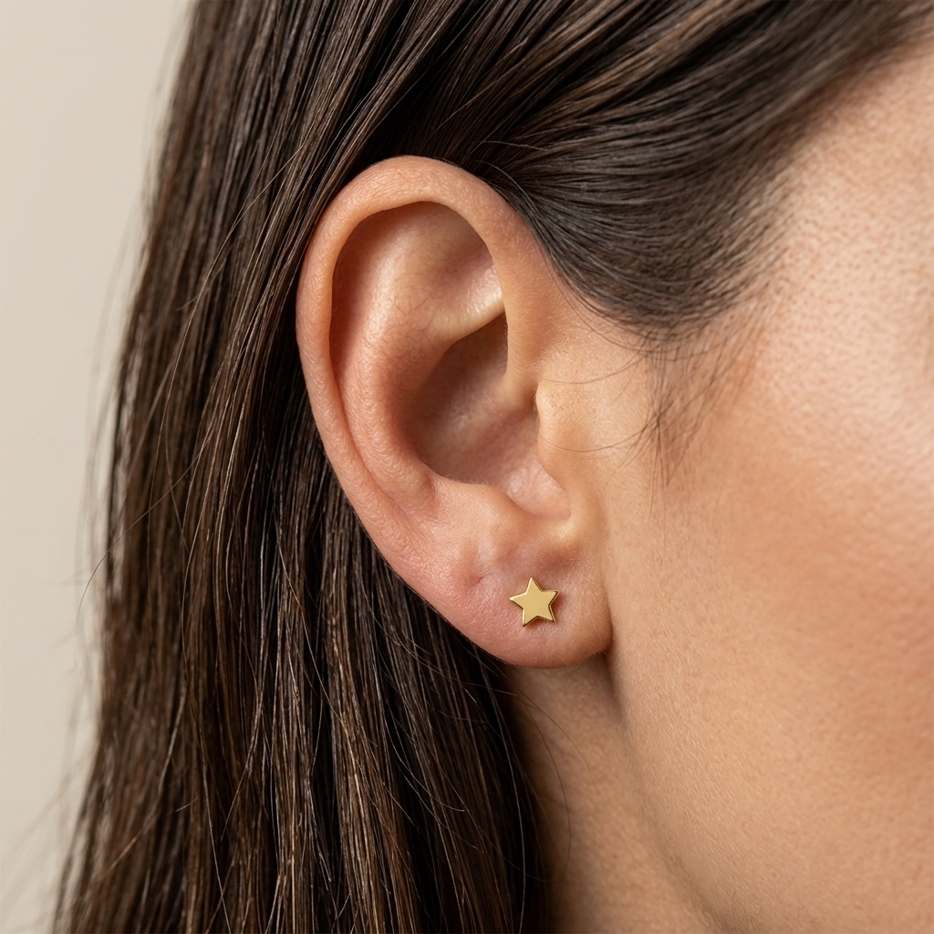 Close-up of 14K yellow gold tiny star stud earrings