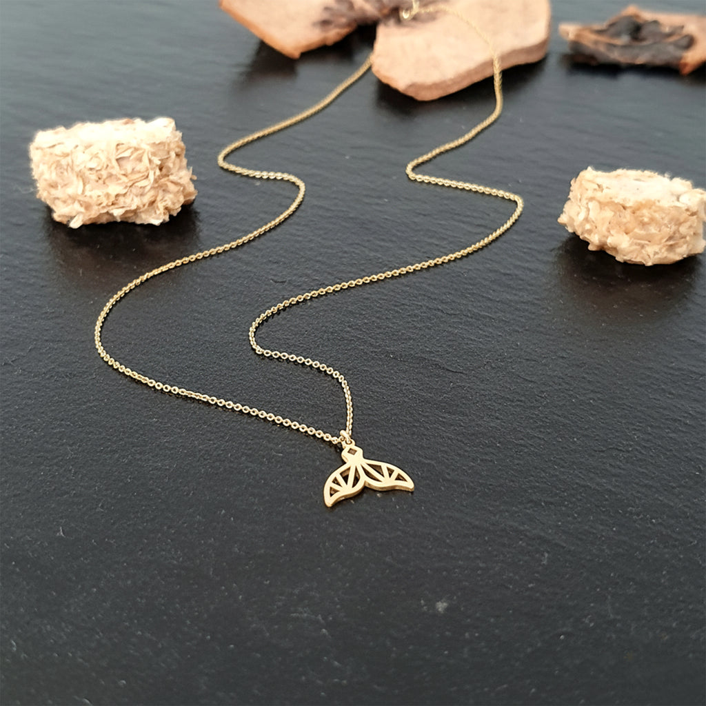 Close-up of 14K yellow gold mermaid tail charm necklace