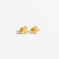 A pair of small gold stud earrings shaped like interlocking puzzle pieces, photographed on a clean white background.