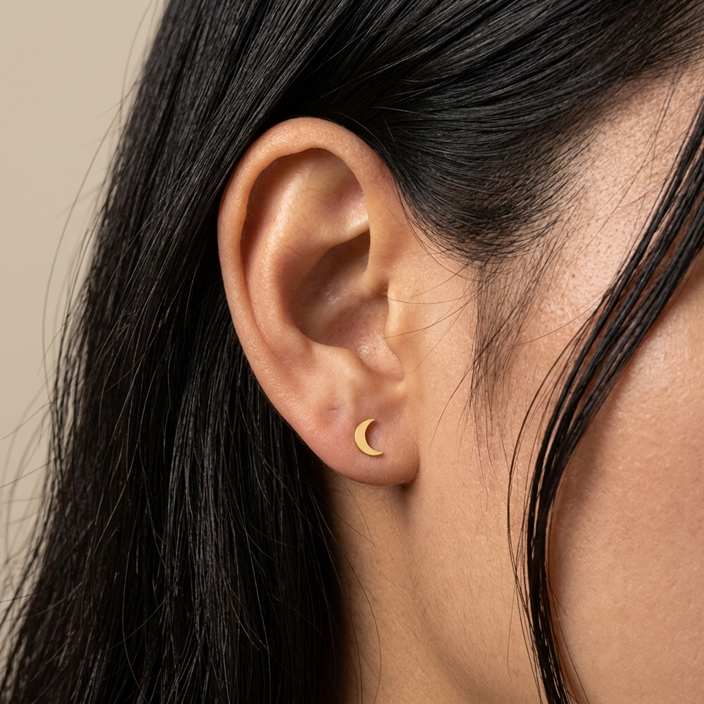 Close-up of 14K yellow gold crescent moon stud earrings