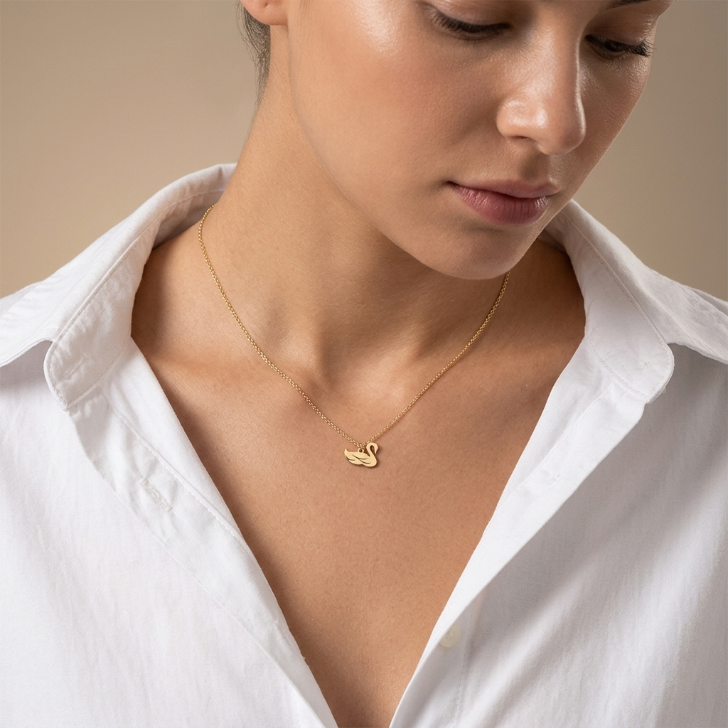 Close-up of 14K yellow gold dainty swan pendant charm necklace