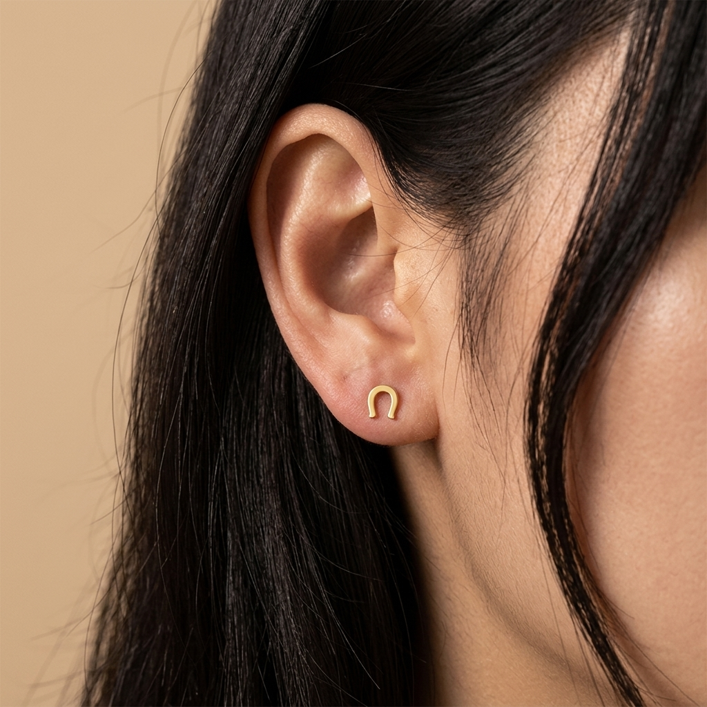 Close-up of 14K yellow gold horseshoe stud earrings
