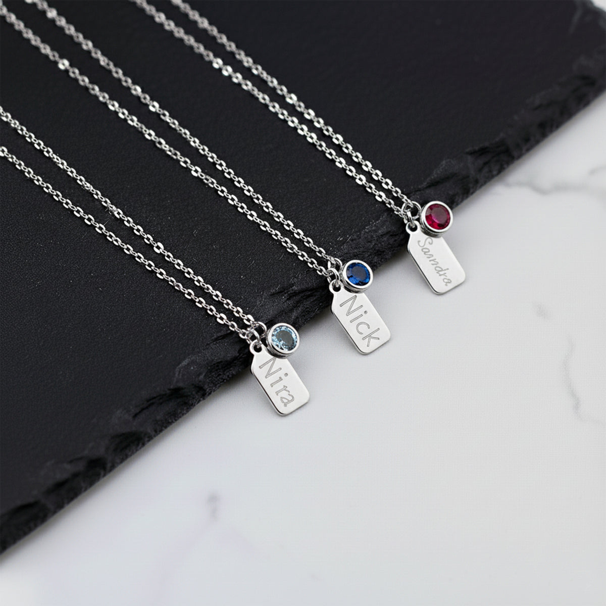 Close-up of 14K white gold personalized name tag necklace with birthstone