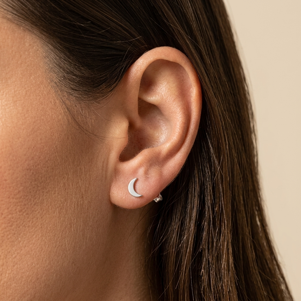 Close-up of 14K white gold crescent moon stud earrings