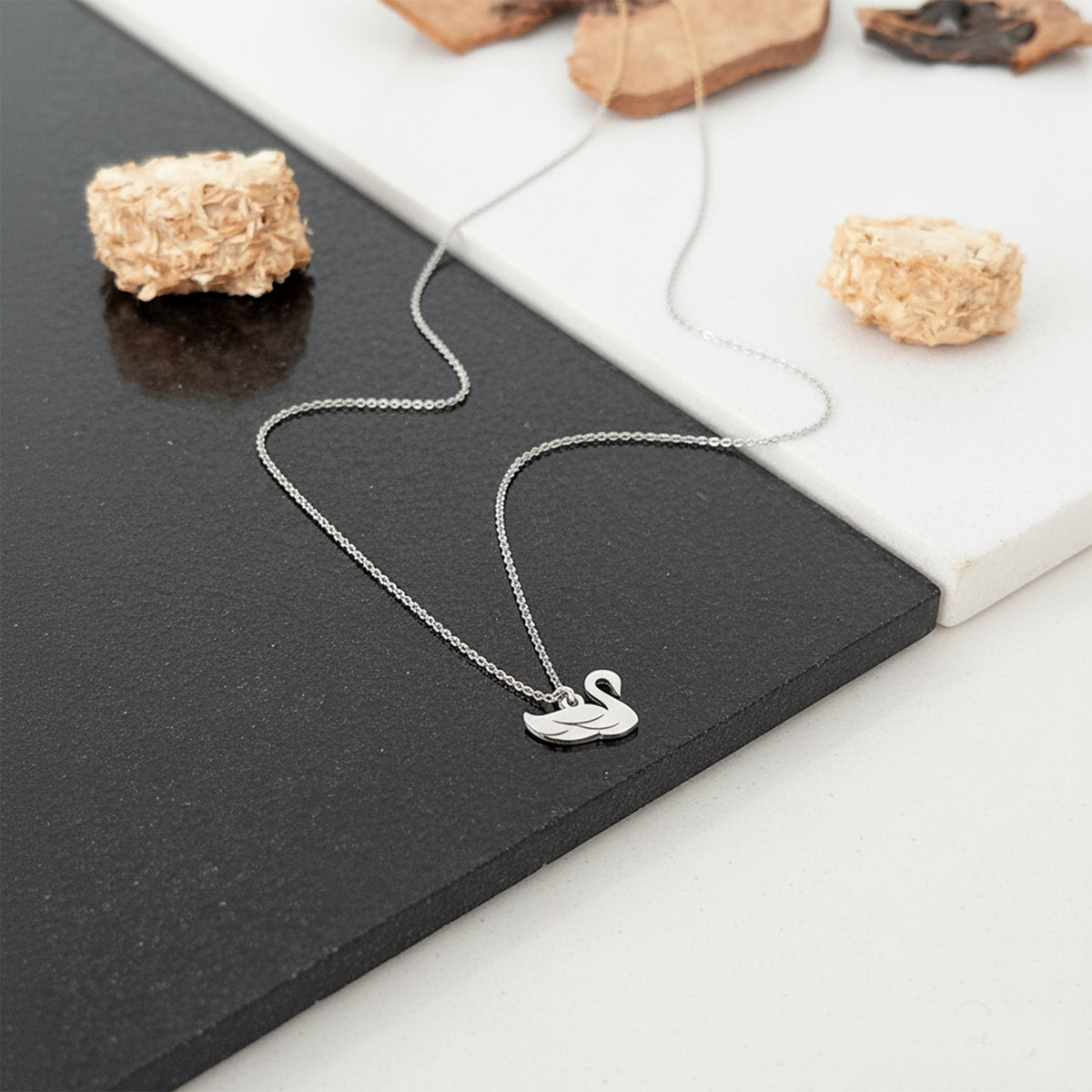 Close-up of 14K white gold dainty swan pendant charm necklace
