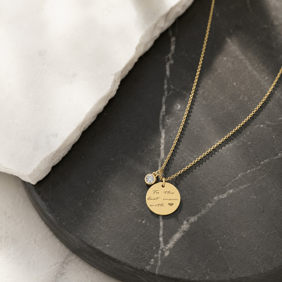 Close-up of 14K yellow gold diamond-set disc necklace with handwriting engraving