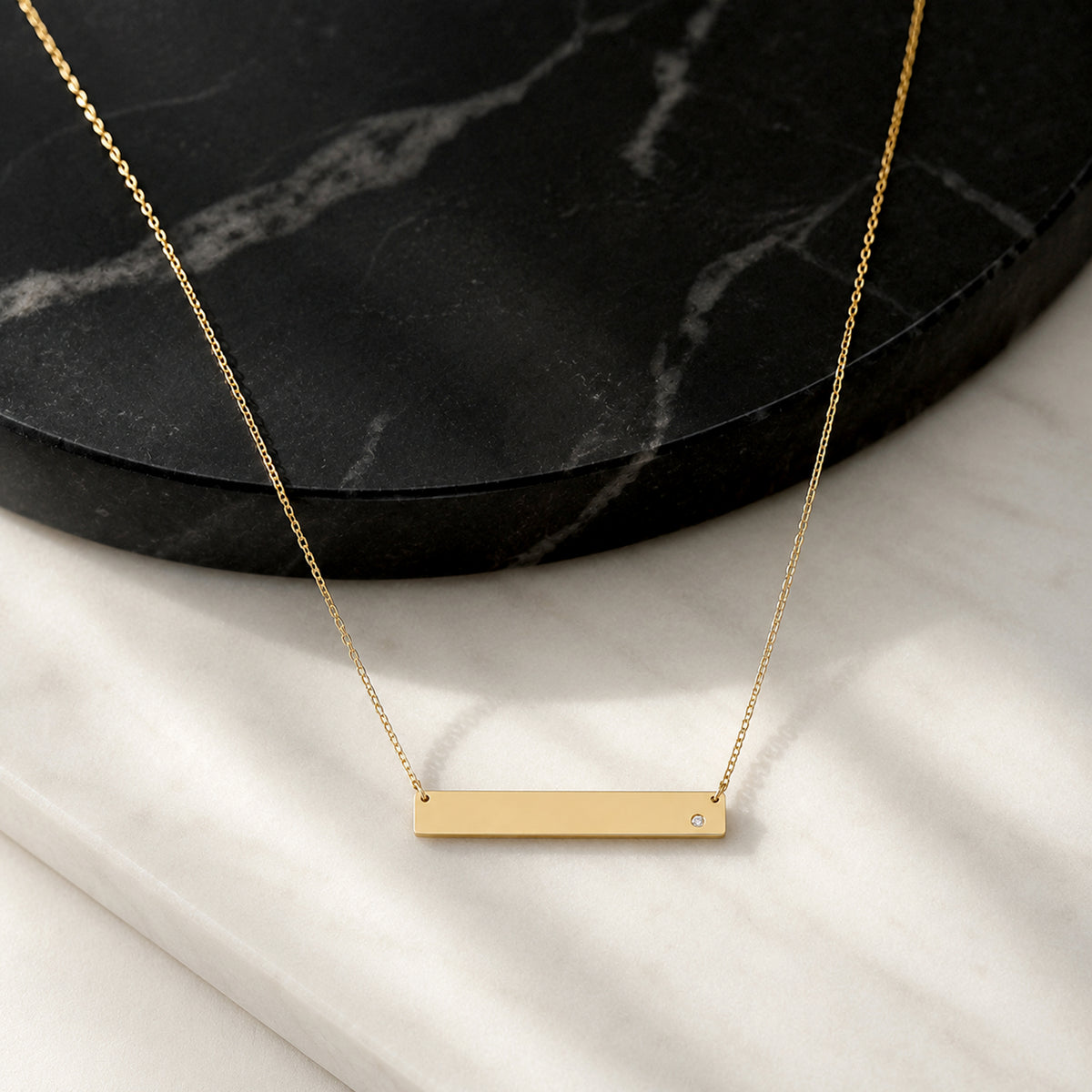 Close-up of 14K yellow gold diamond name bar necklace