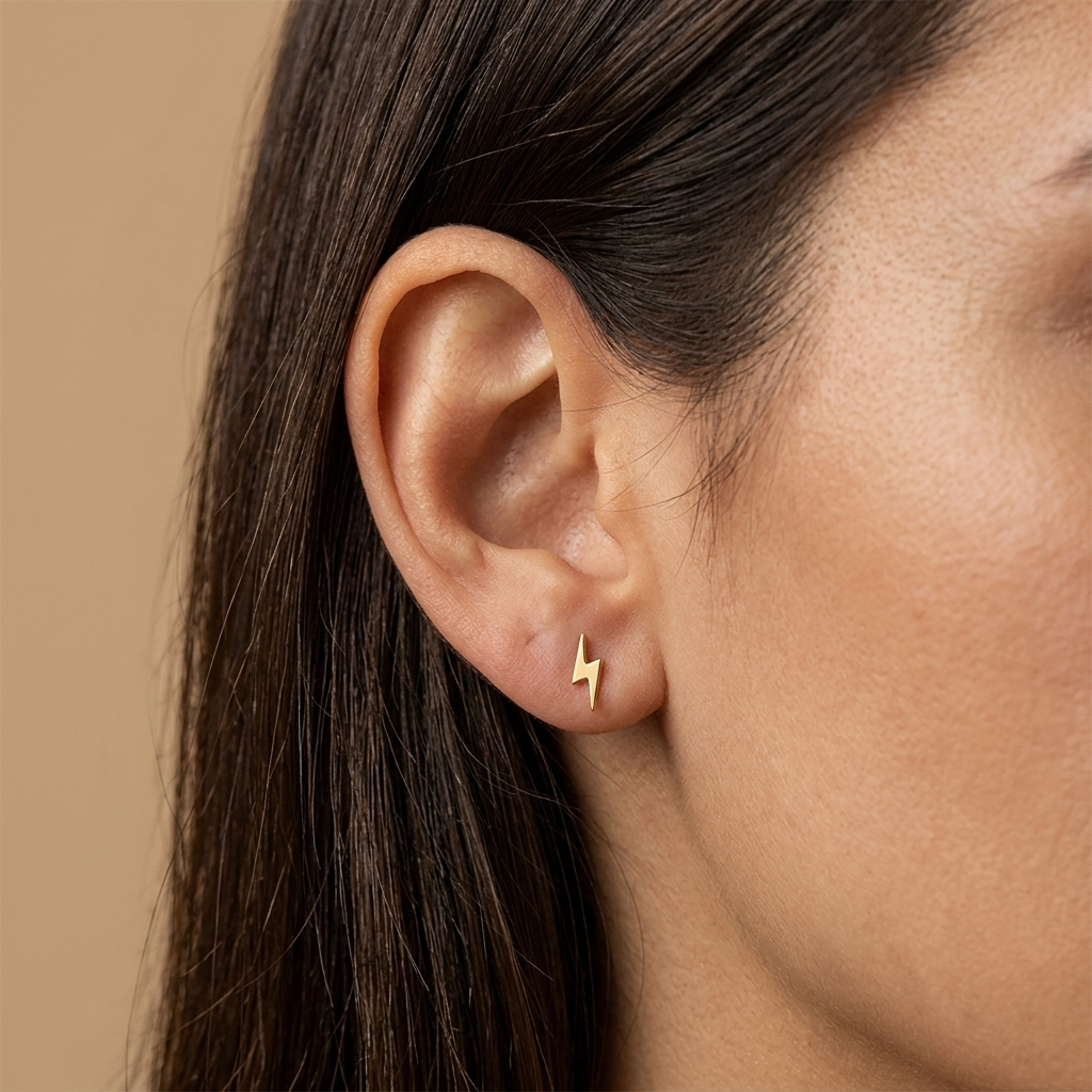 Close-up of 14K yellow gold everyday lightning bolt stud earrings